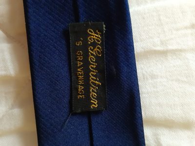 Het eigen kledingmerk op een stropdas.