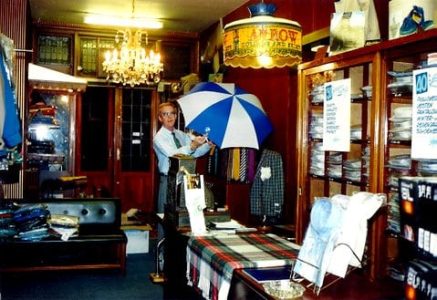 De heer Gerritzen bij de toonbank met de Tiffany's lamp erboven.