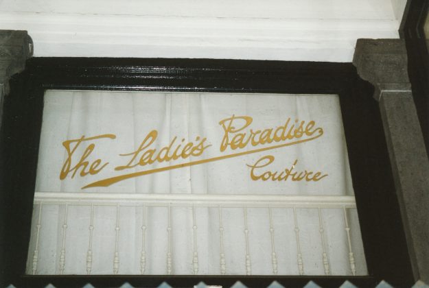 Raam boven ingang aan de Kettingstraat met reclameschildering, 2002. The Ladies Paradise, hoedenwinkel, Passage 7, jaren 20